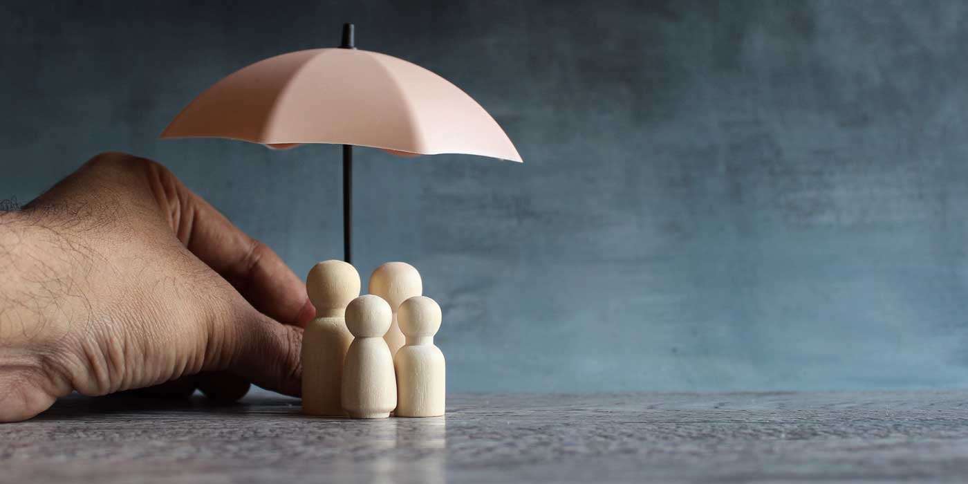 wooden figure family under an umbrella